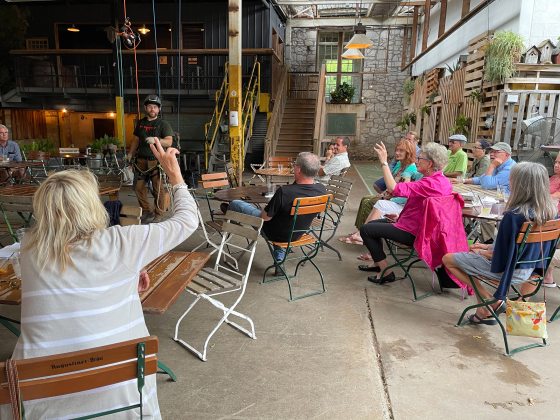 people seated at tables listening to a presentation